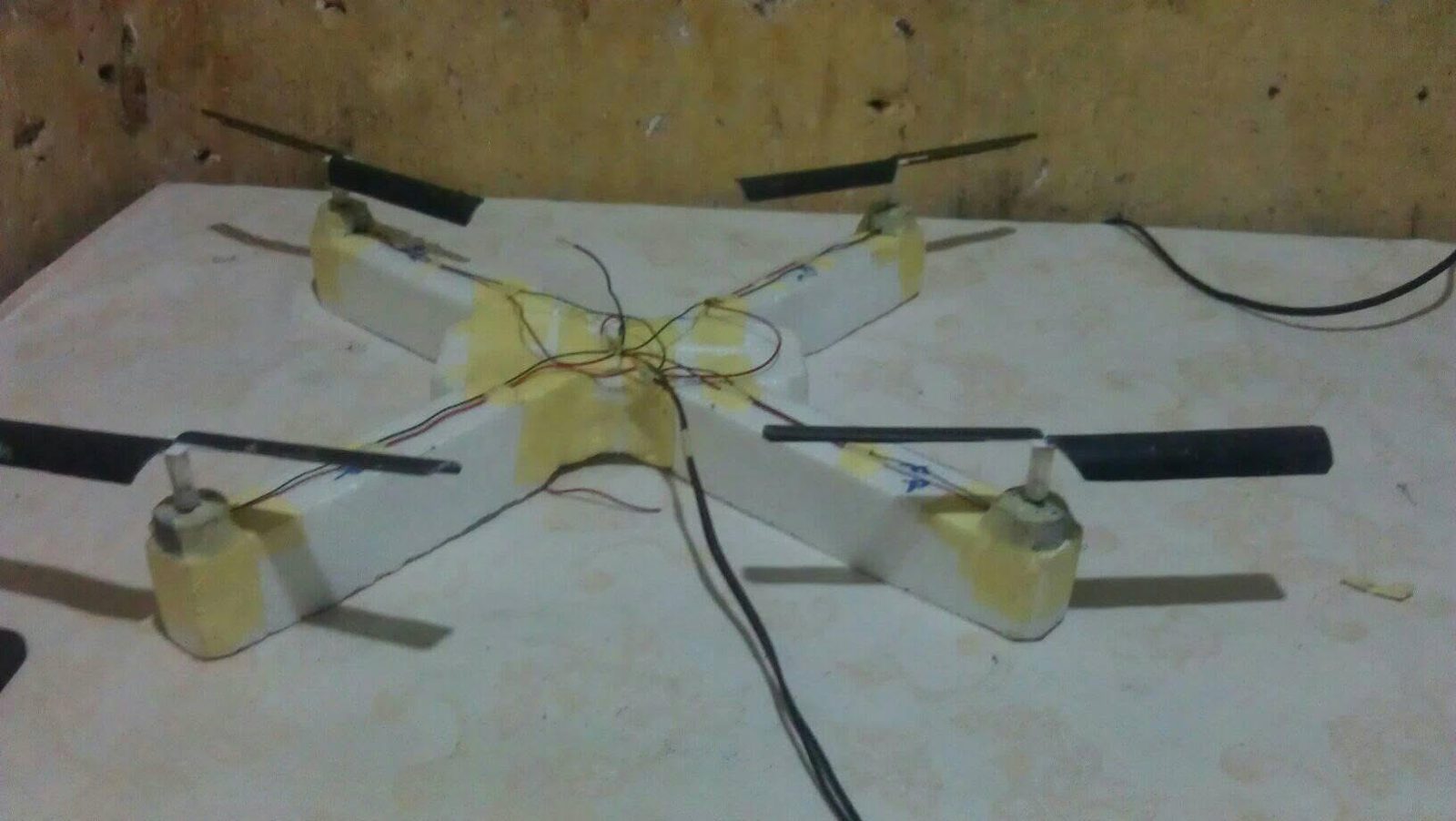 A home-built quadcopter frame on a workbench.