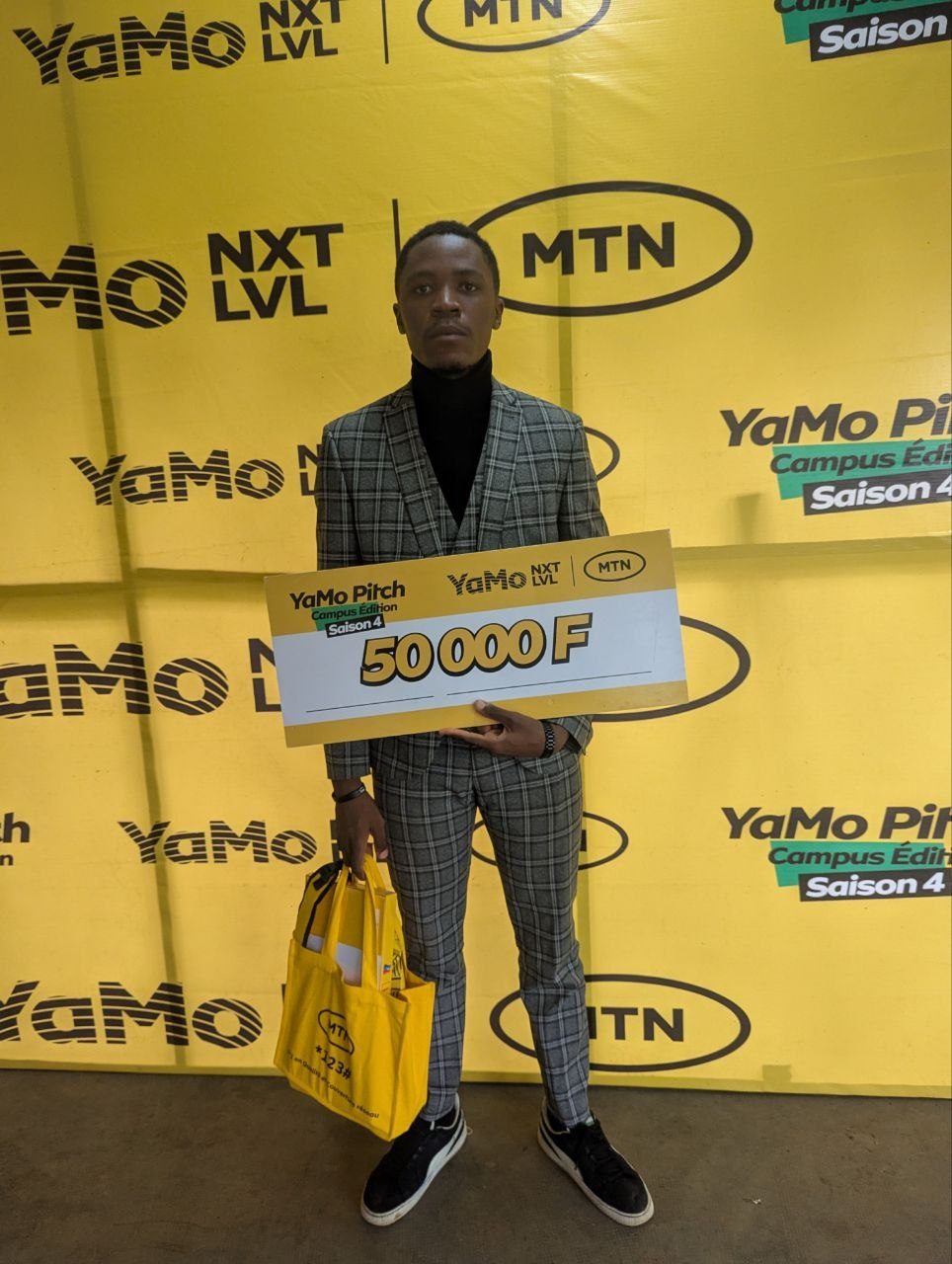 Chifen on the MTN YaMo Pitch Season 4 stage holding the prize cheque.